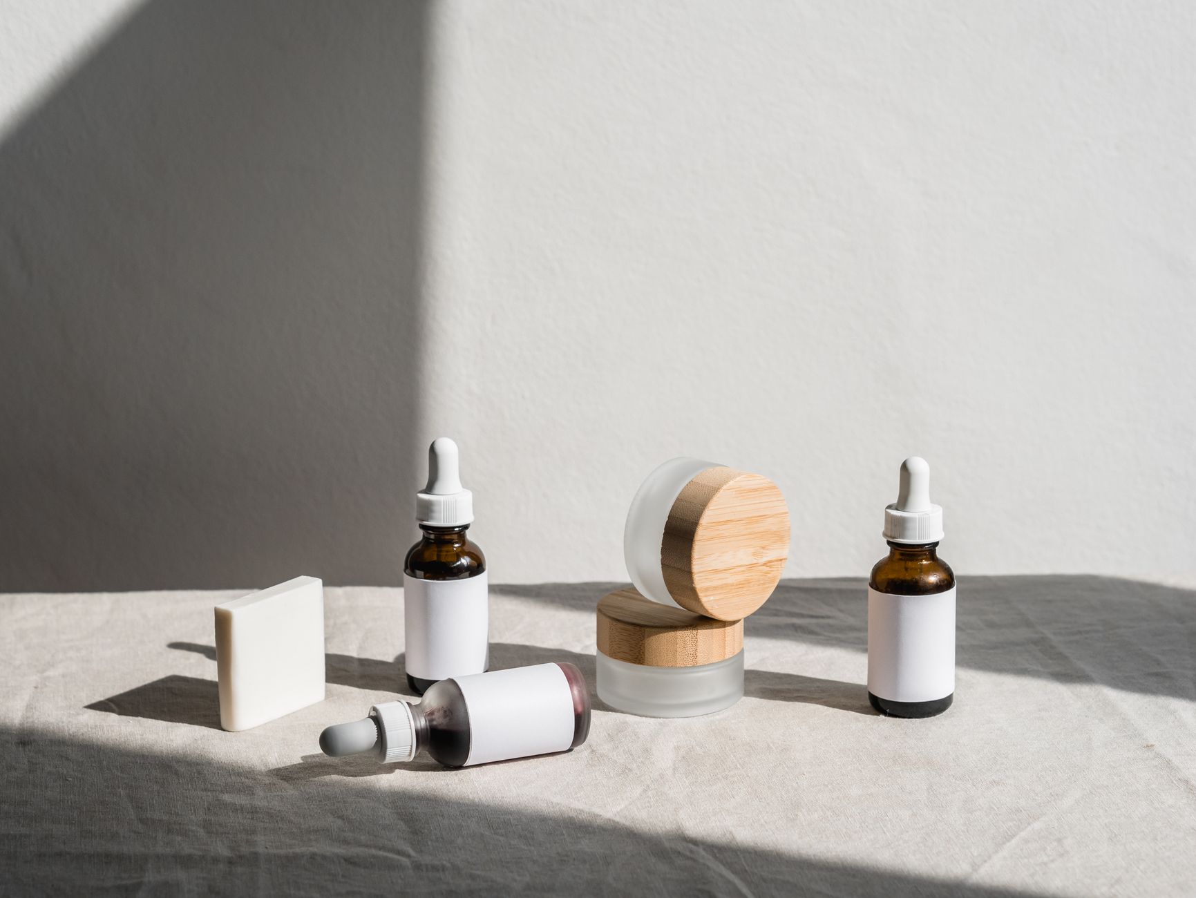 Cosmetic bottles and jars lined up on a laboratory shelf beside regulatory compliance paperwork